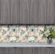 Tile mural with stylized tropical leaves and cream-colored hibiscus flowers in beige and green tones