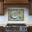 ceramic tile mural with sardines and lemon kitchen scene