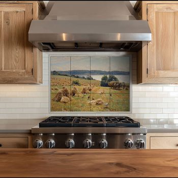 Ceramic tile mural with peasant woman harvesting among grain sheaves, mountain landscape in the background